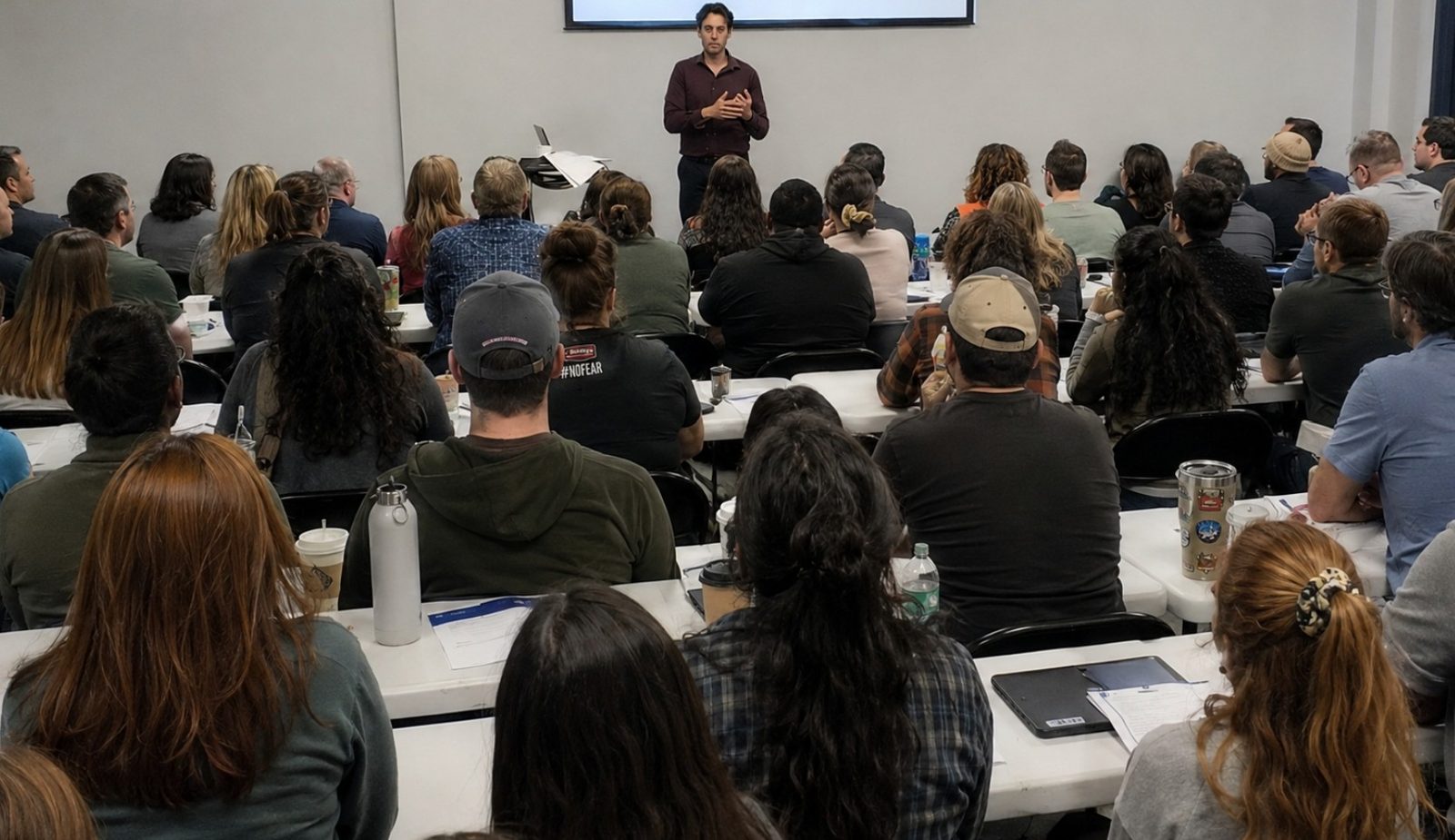 Kenneth Applegate presenting to a full room of adults
